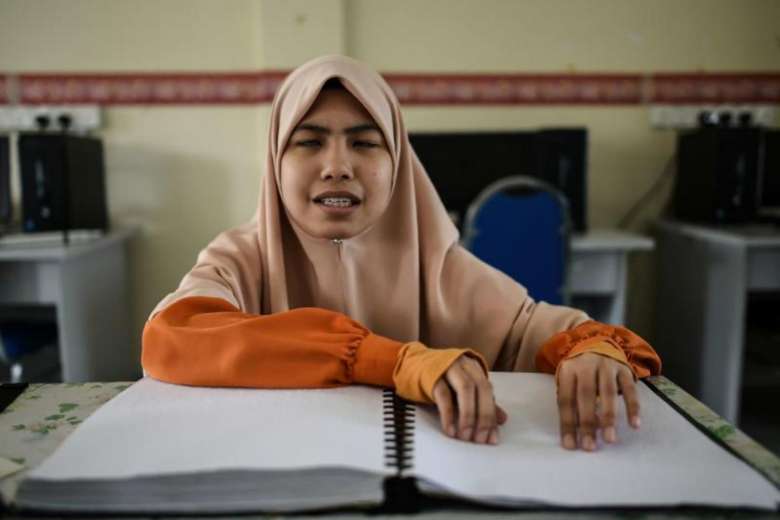 Cara OKU Penglihatan sedang membaca Al Quran Braille